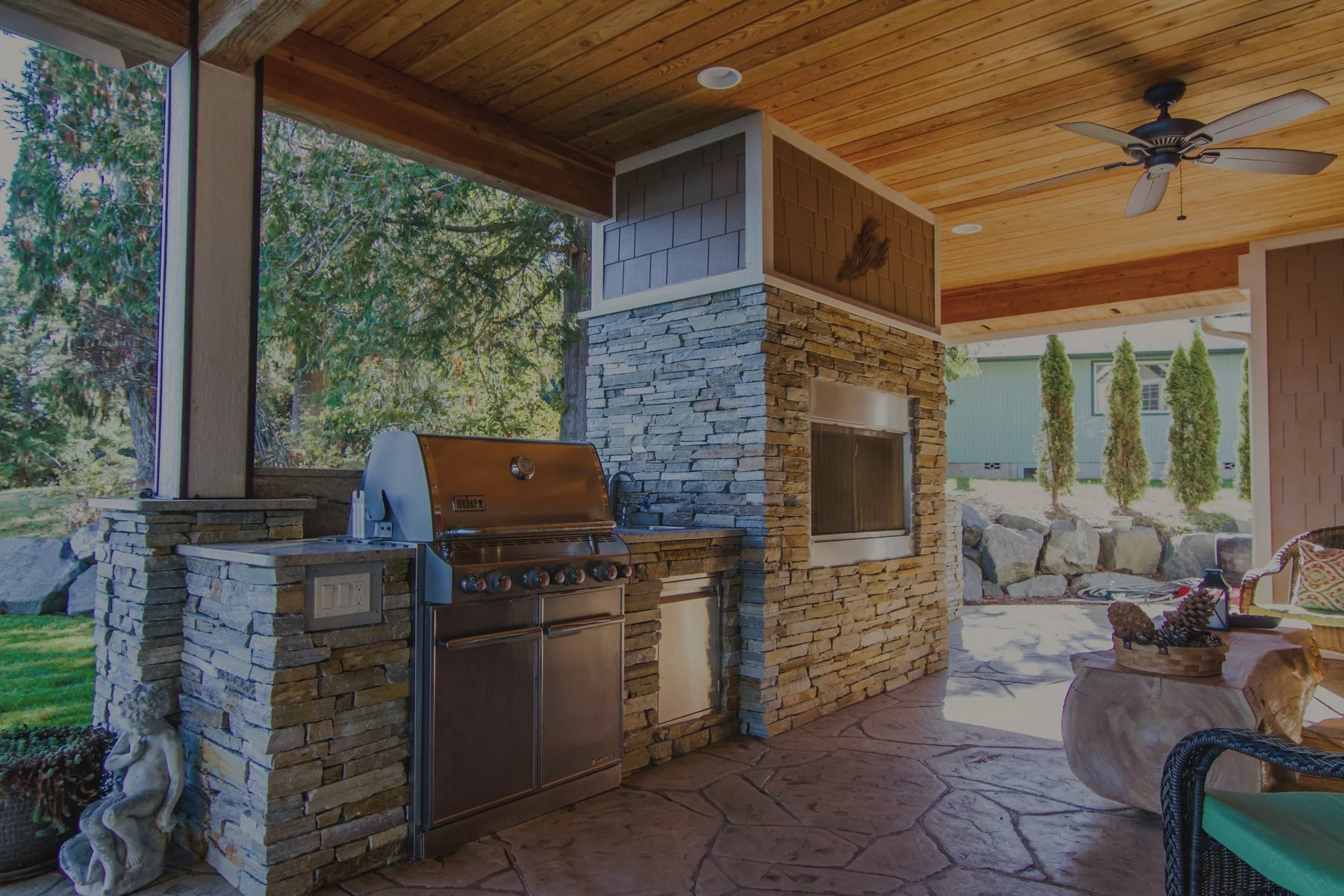 Rod's custom waterfront home on Henderson Inlet featuring outdoor kitchen with built-in grill and stone fireplace - FoxHead Construction Thurston County