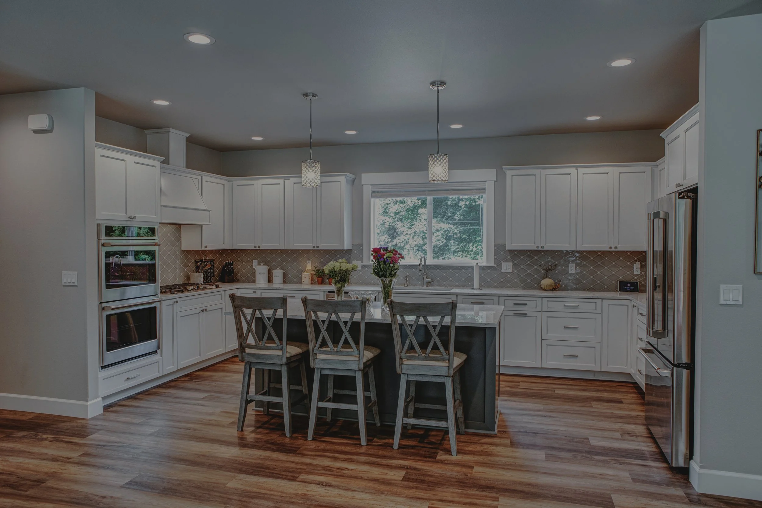 David's custom home in Olympia featuring white kitchen with vaulted ceilings and timber frame covered patio - FoxHead Construction Thurston County