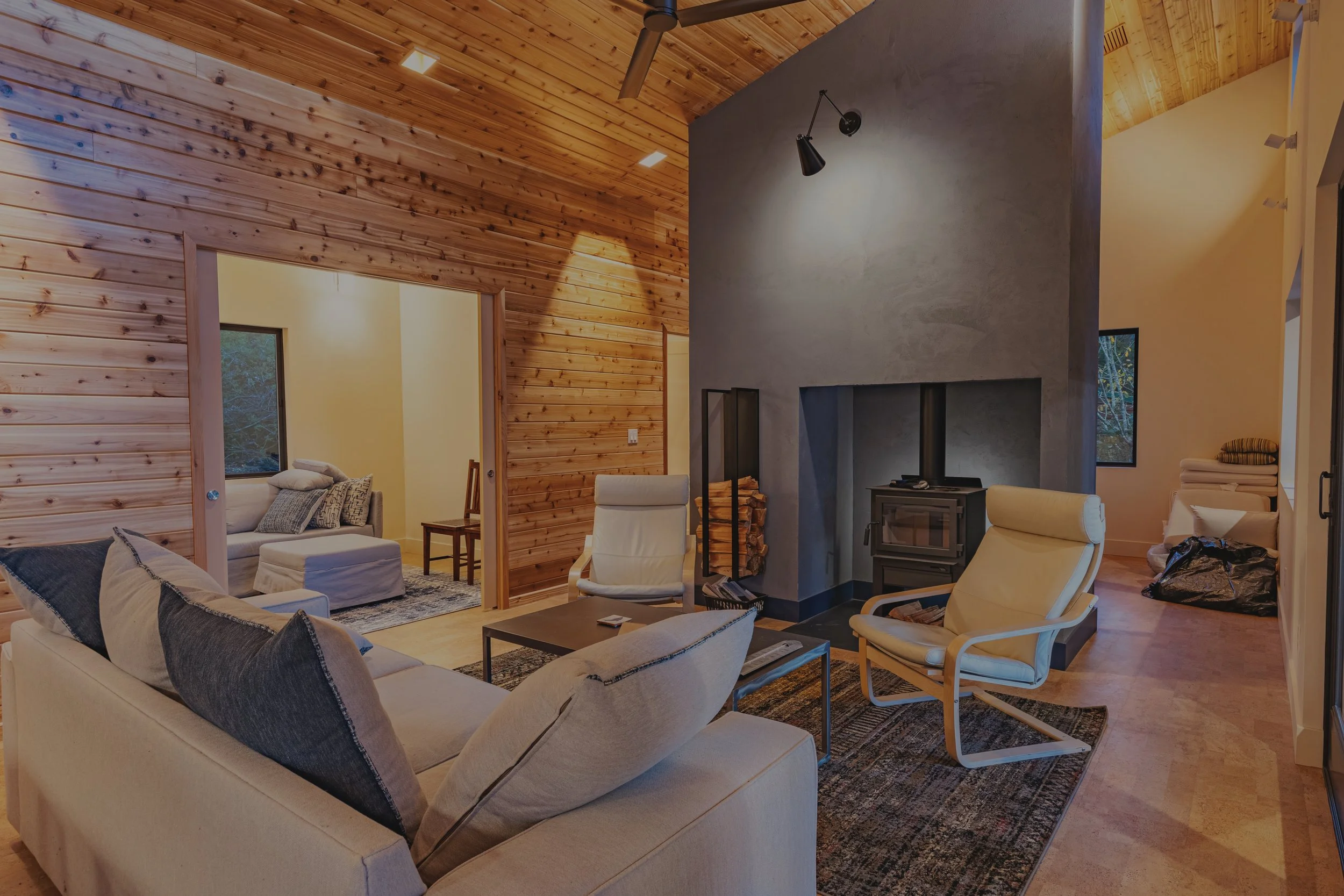 Contis' custom cabin on Harstine Island featuring natural wood ceilings and wood-burning stove - FoxHead Construction Mason County