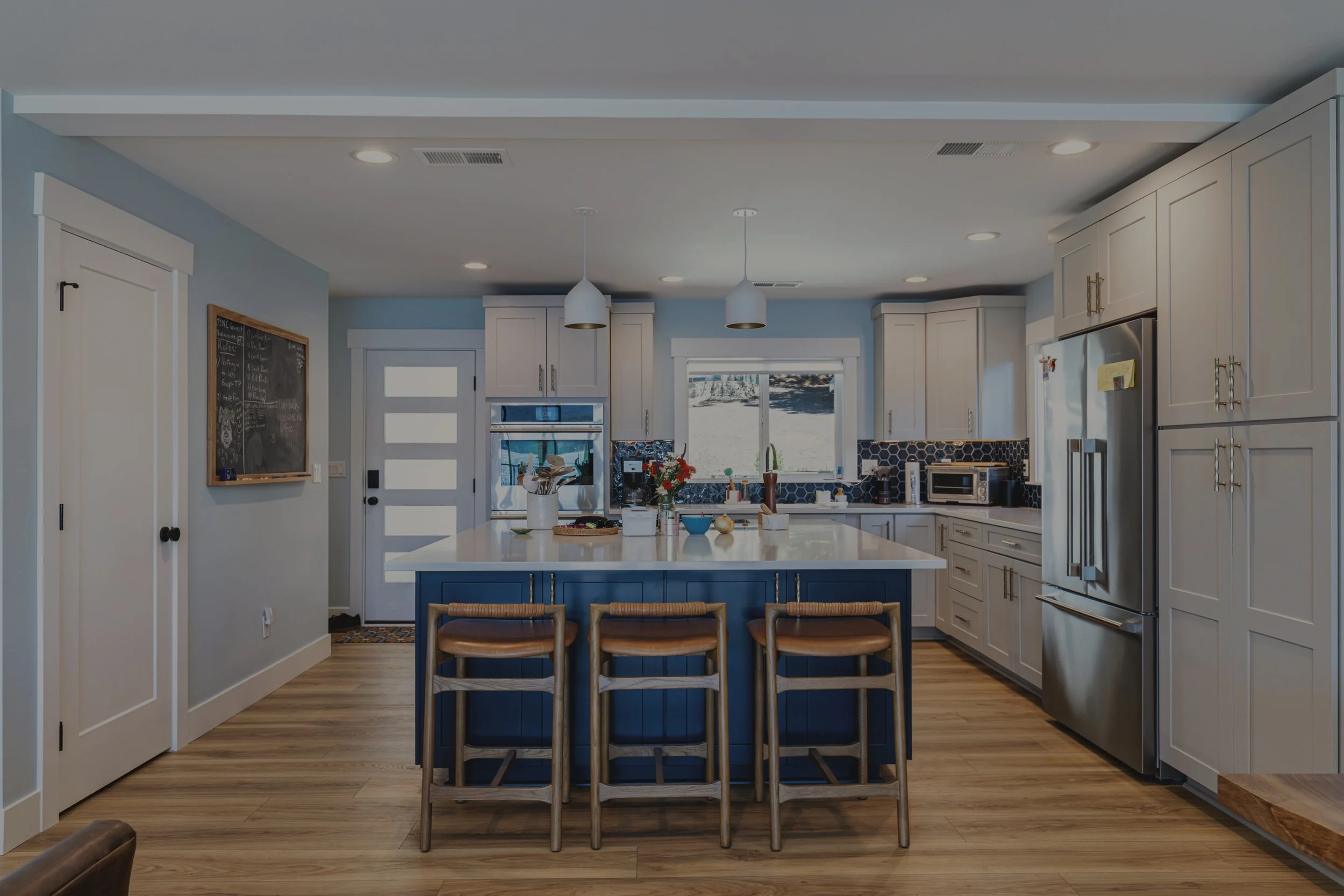 Cain's whole home remodel on Lake Cushman featuring two-tone kitchen with navy blue island and white cabinets - FoxHead Construction Mason County