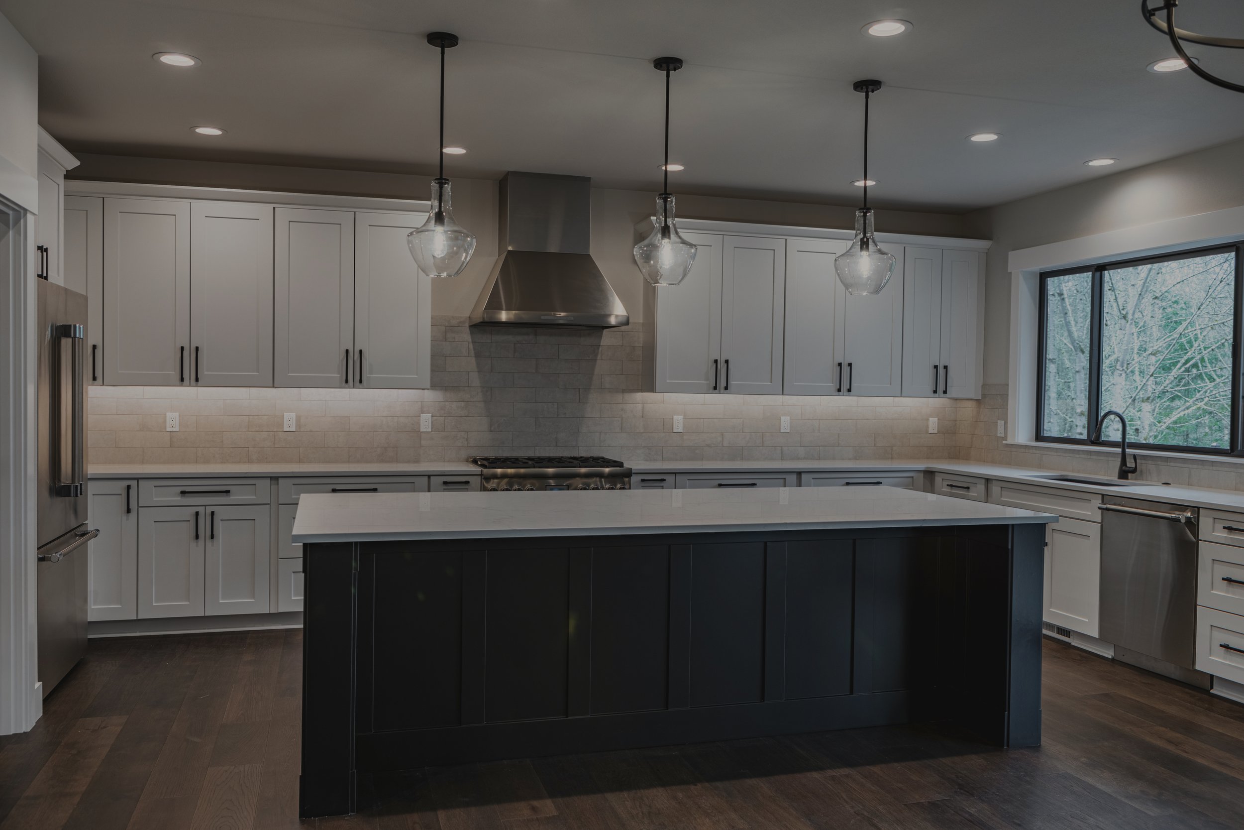 Clark's modern custom home in Olympia featuring large kitchen island and multi-level deck system - FoxHead Construction Thurston County