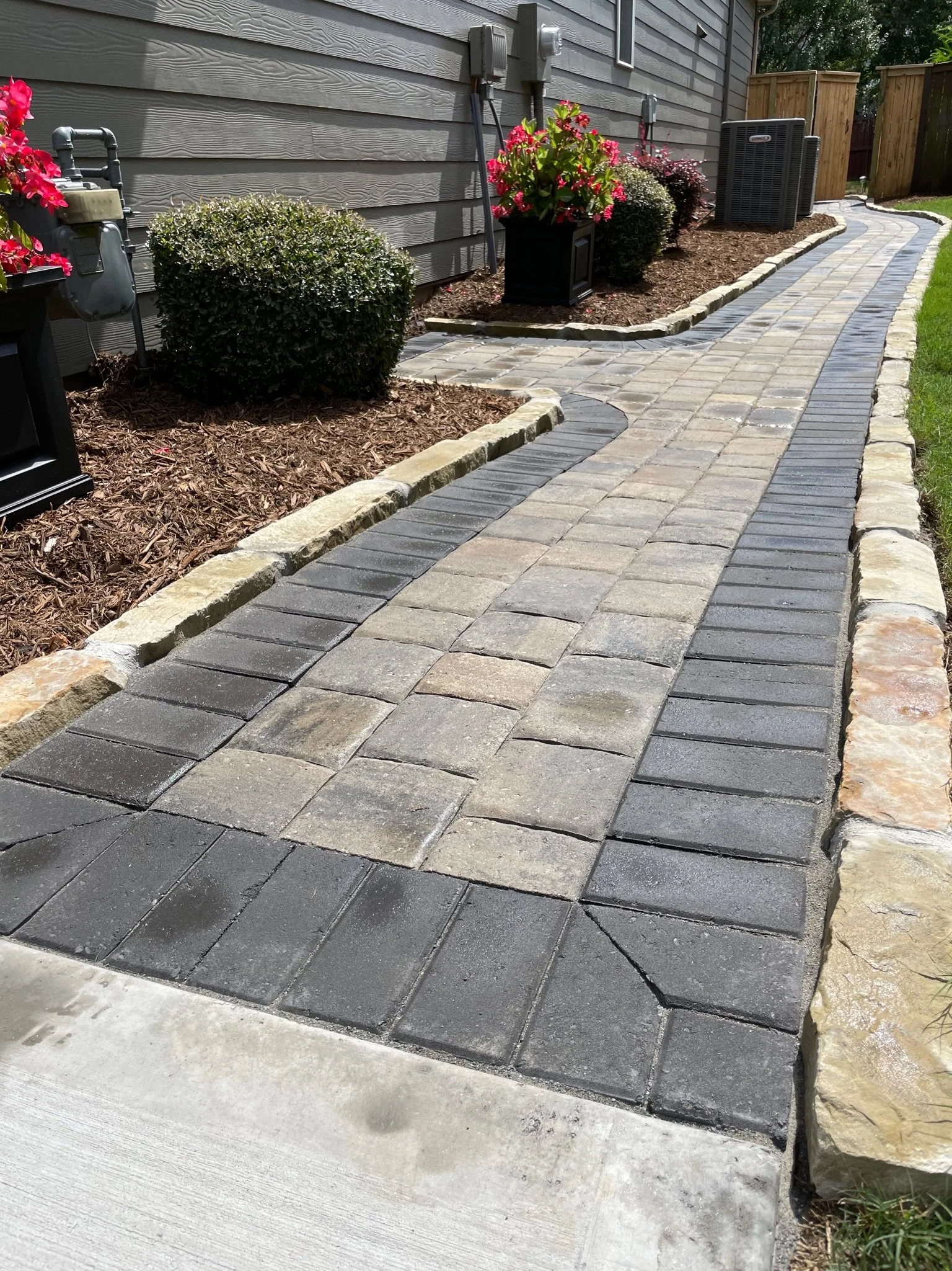 Shaded patio with curved walkway and rustic brick wall in Greer, SC