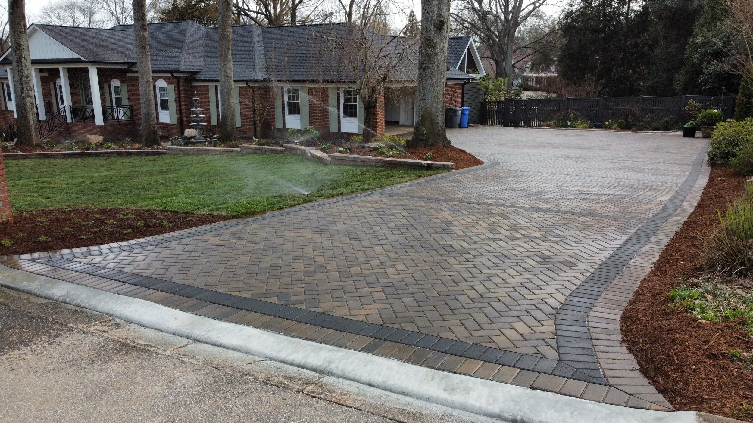 Dark herringbone paver driveway bordered with soldier course in Mauldin, SC