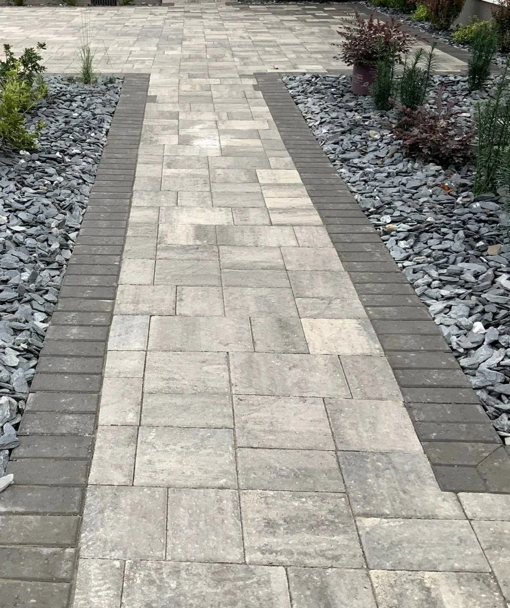 Stone walkway with mulch and flowering plants leading to backyard in Greer, SC