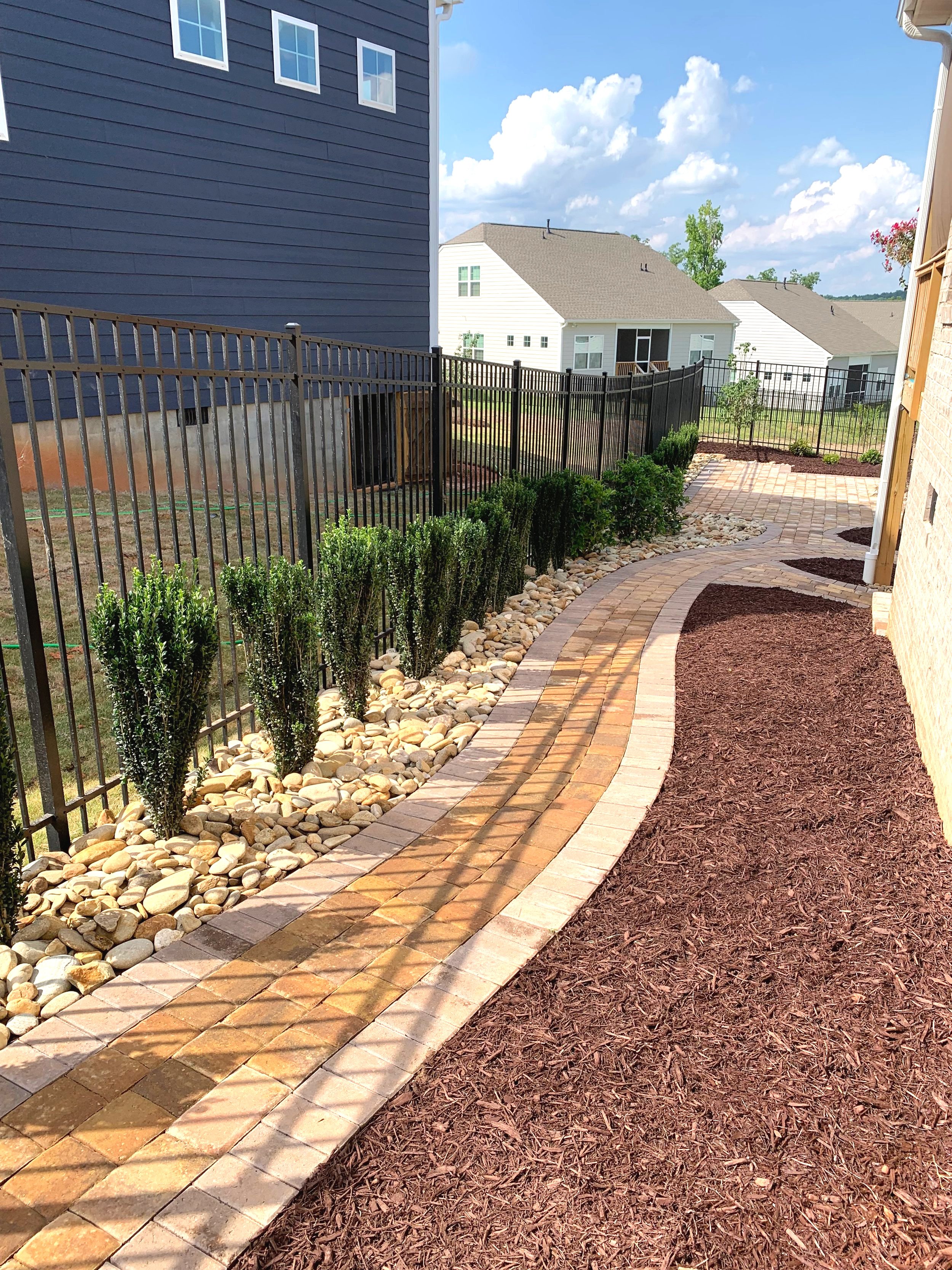 Light paver walkway leading to circular fire feature and back porch in Mauldin, SC