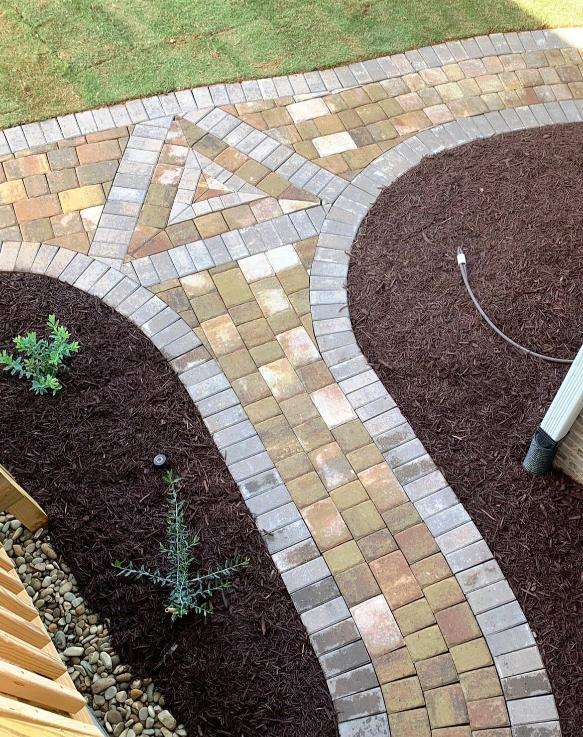Curved walkway made of multicolor pavers with garden wall in Five Forks, SC