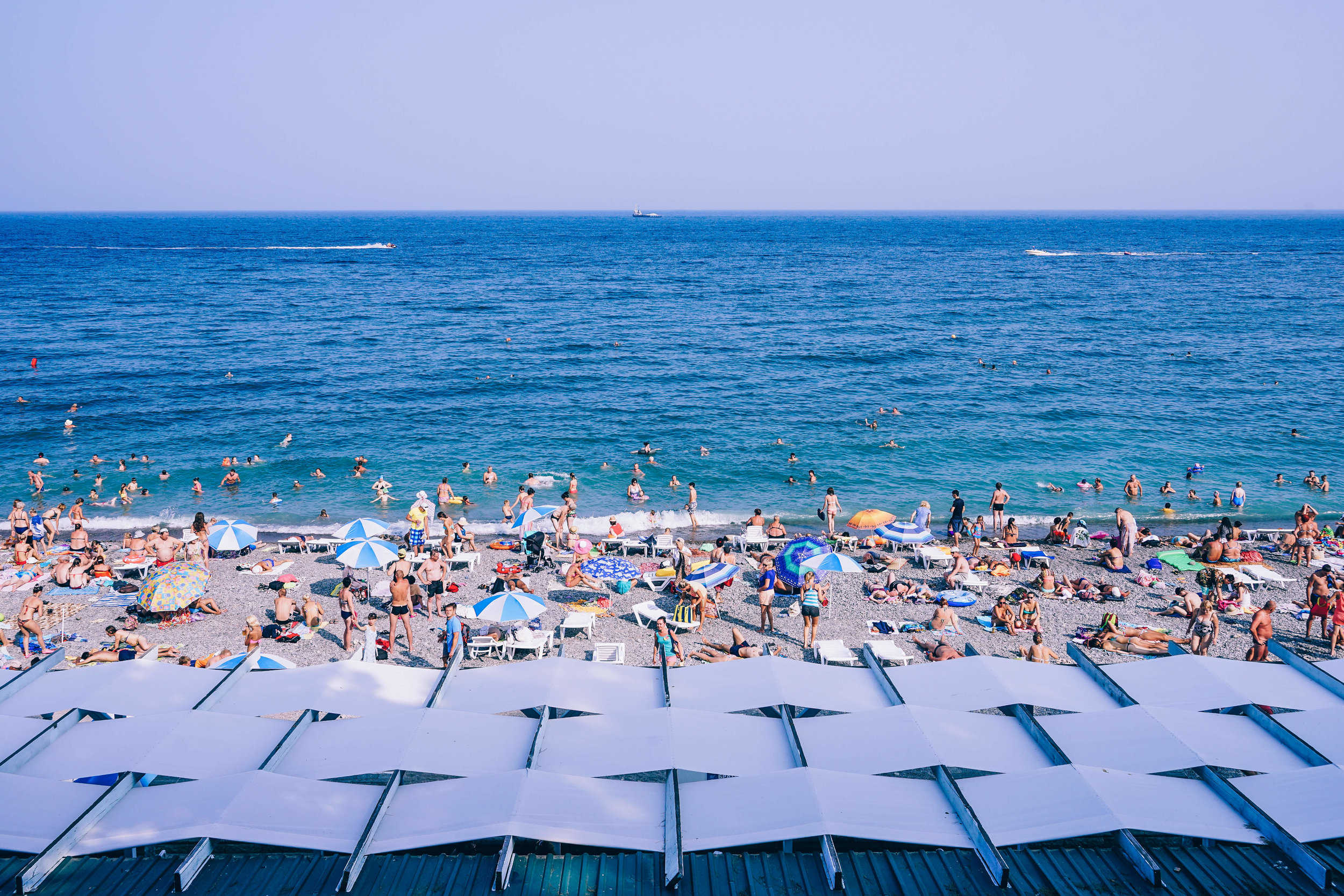 Busy beach with rows of umbrellas along the ocean