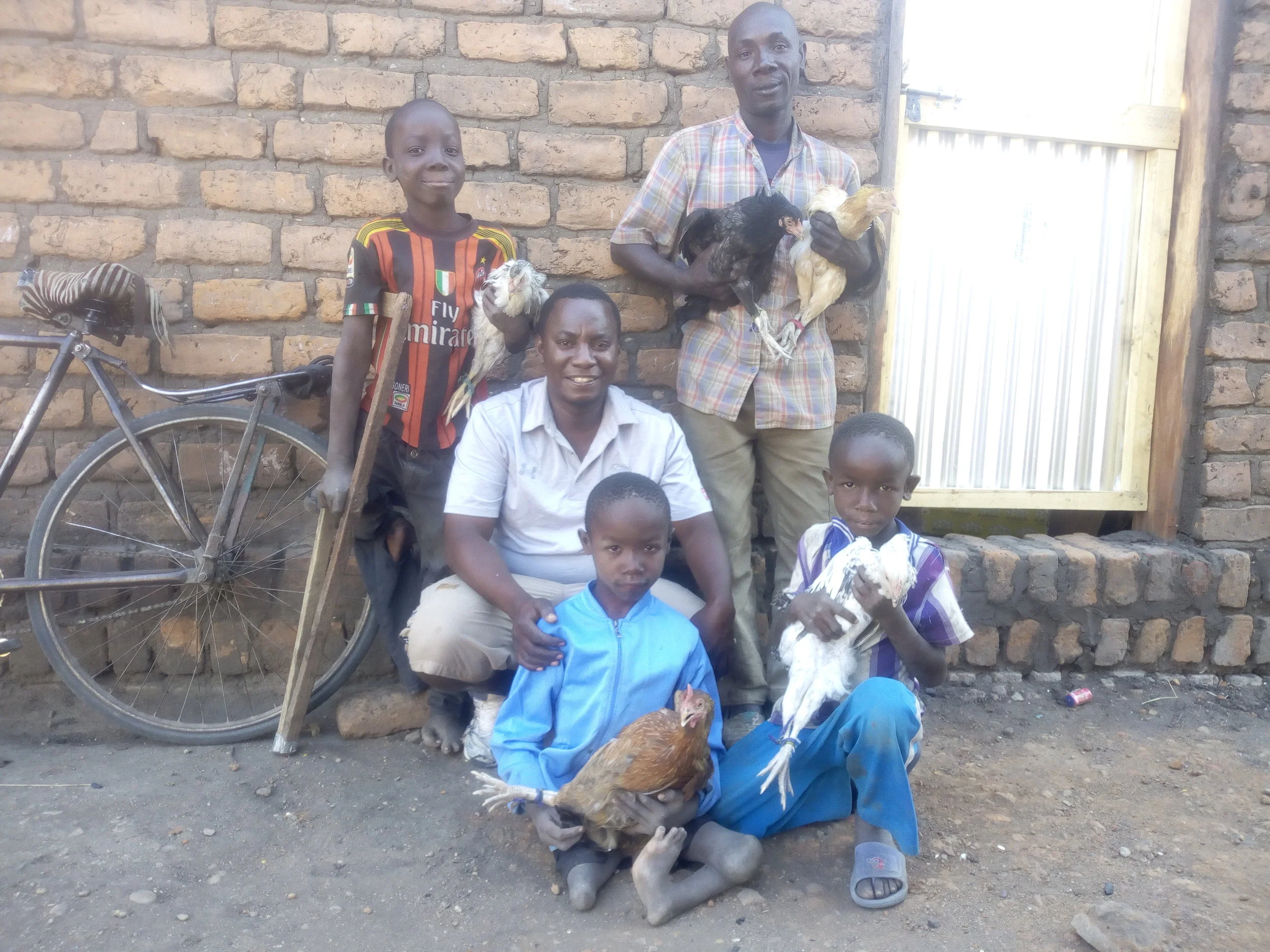 Bahati Hillary (white T shirt) sharing a smile with one of the beneficiaries