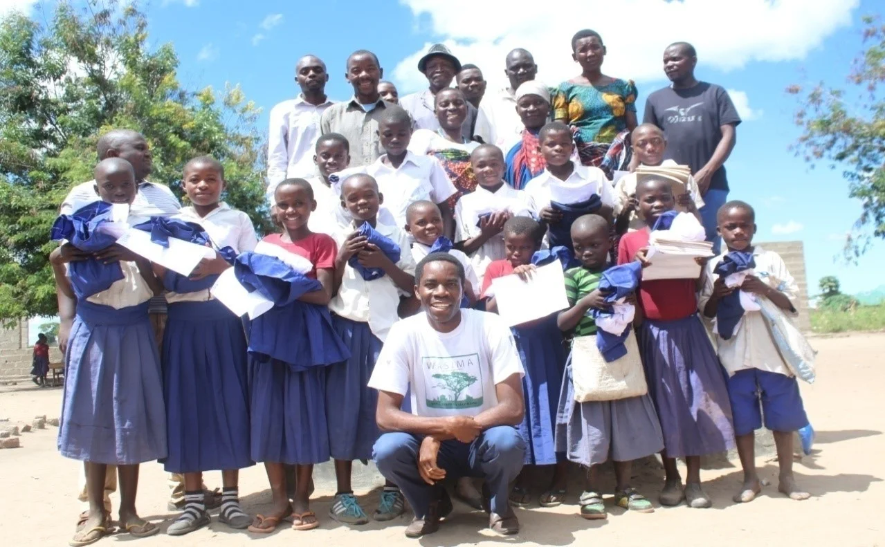 Jonathan in a group photo with program awardees (pupils) and guardians at Luchima village (70km from Usevia , but 0.7 katavi park boundary) .