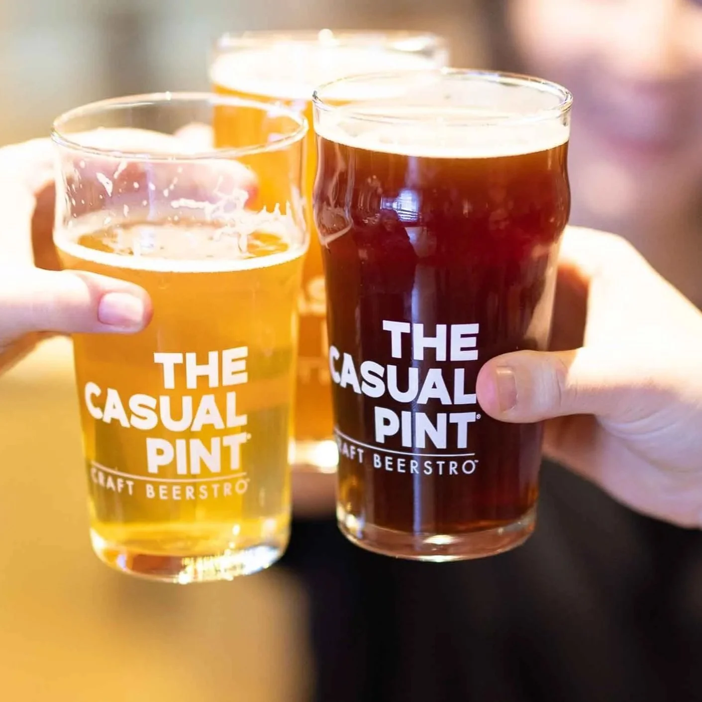 Beer glasses cheersing each other at Casual Pint in Countryside Village