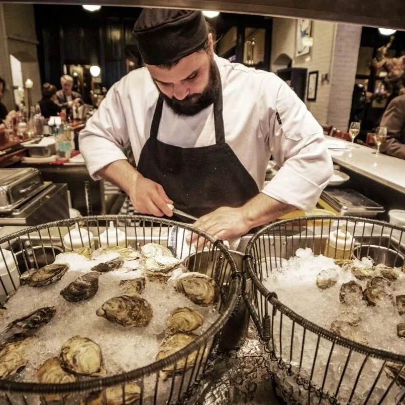 Mussels being cut open at Le Bouillon, a classic French restaurant in Omaha that composts