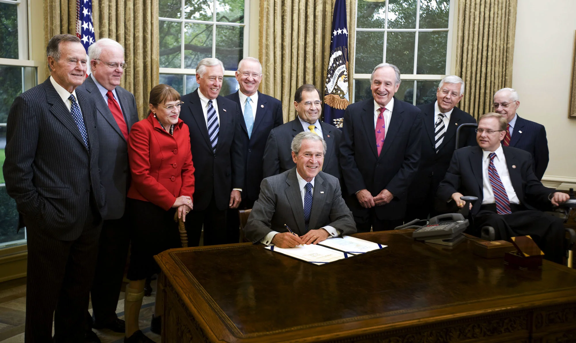 George W. Bush signs the ADAAA. Standing around him is George Bush and Members of Congress.