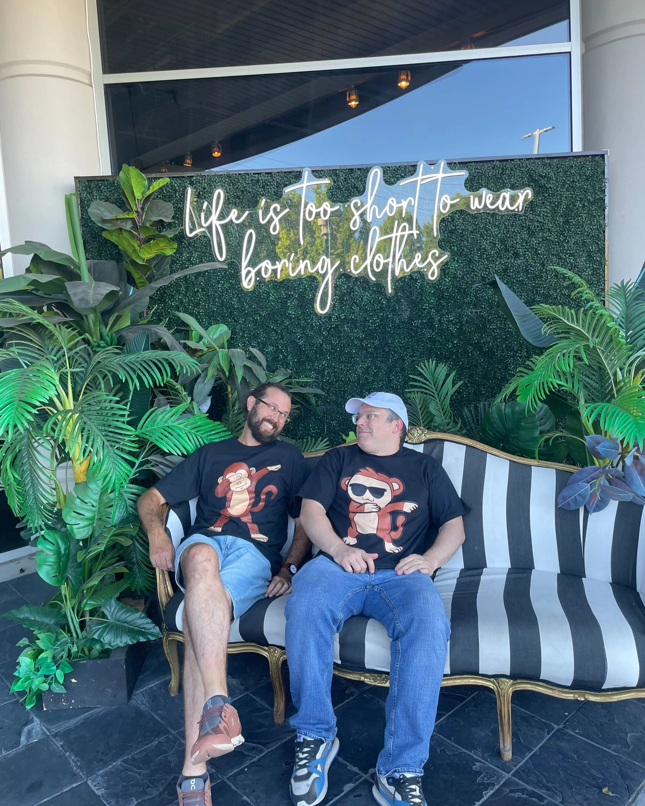 Evan and Vinny confirming the neon slogan "Life is too short to wearing boring clothes"