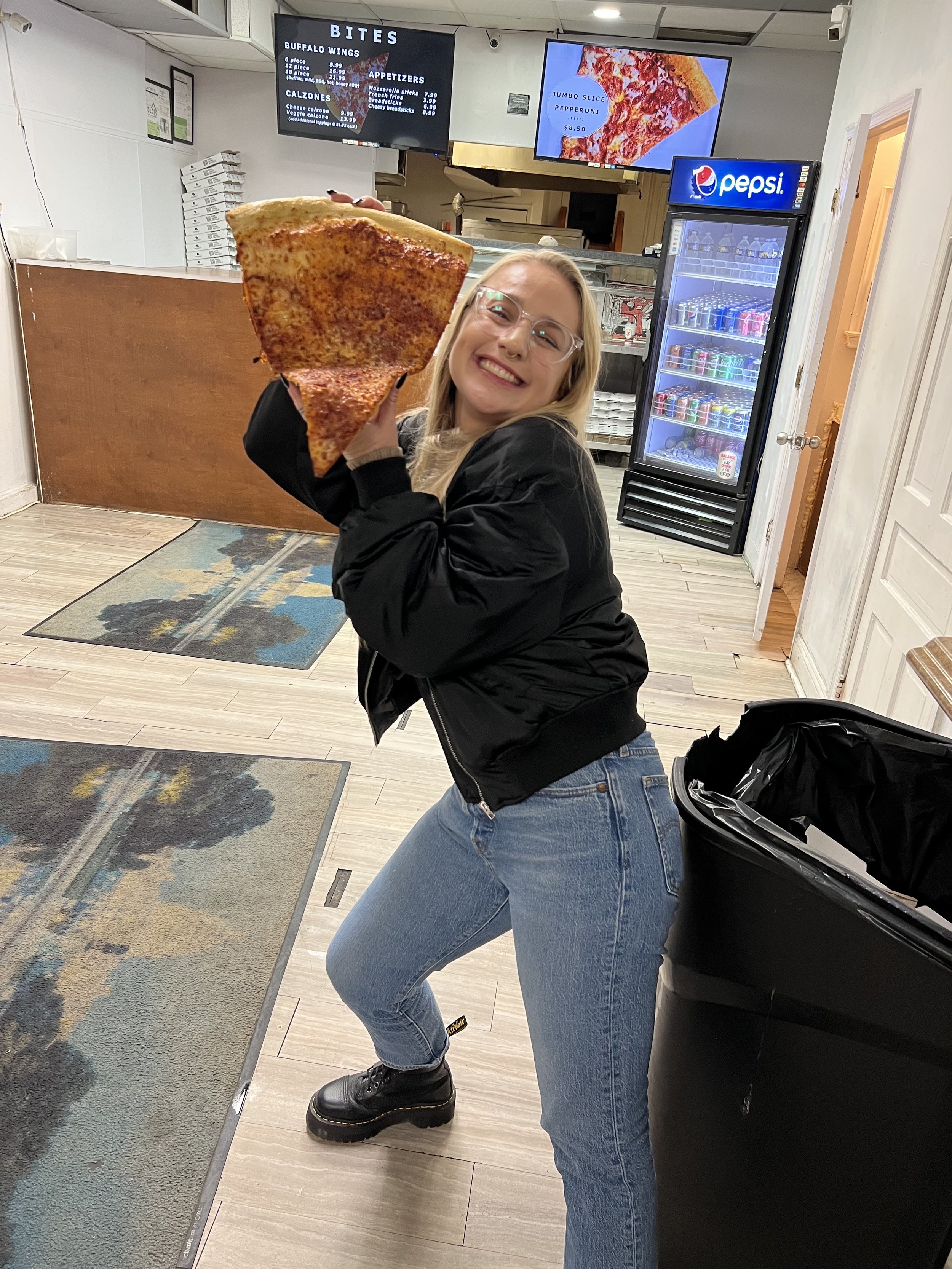 Kati gets a jumbo slice of pizza after chairing her SfN 2023 nanosymposium. 