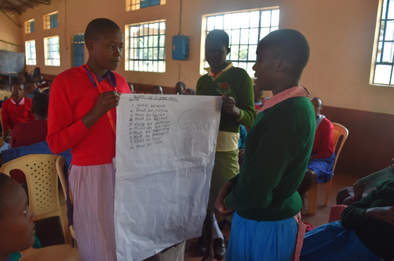 Girls work together to complete an exercise during a Health & Leadership Training