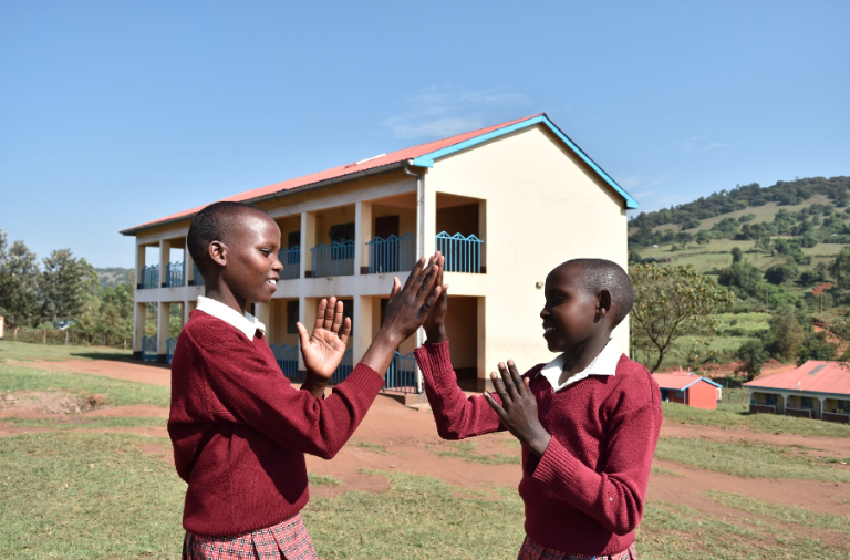 Two girls play outside at the Kakenya Center for Excellence campus