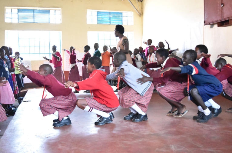 Girls participate in a yoga class during a Health & Leadership Training