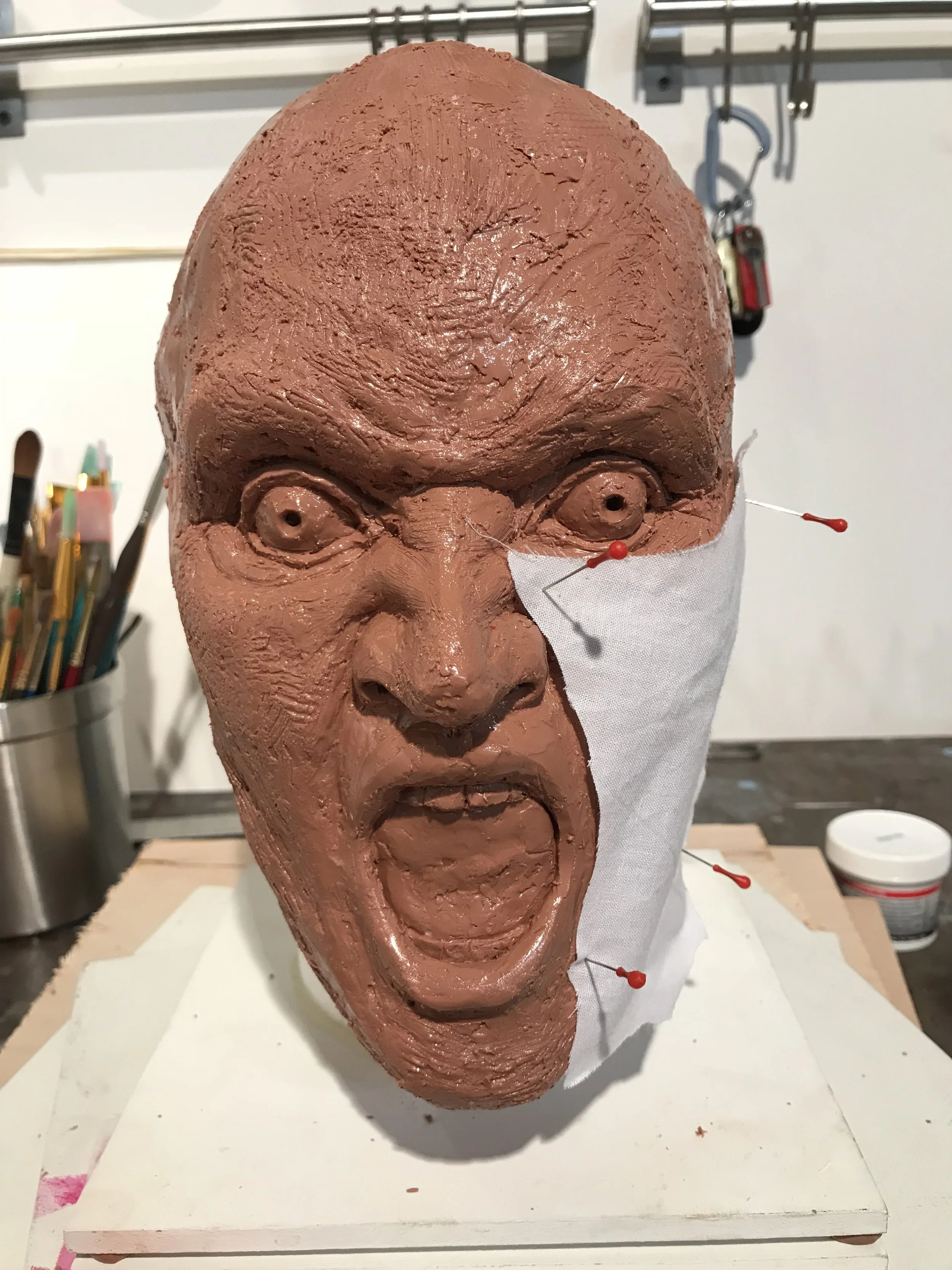 Here's the finished base form, shellacked for protection, with the first fabric panel pinned in place. I may have overdone the level of detail, but it was fun. I love figure sculpture and I miss it!