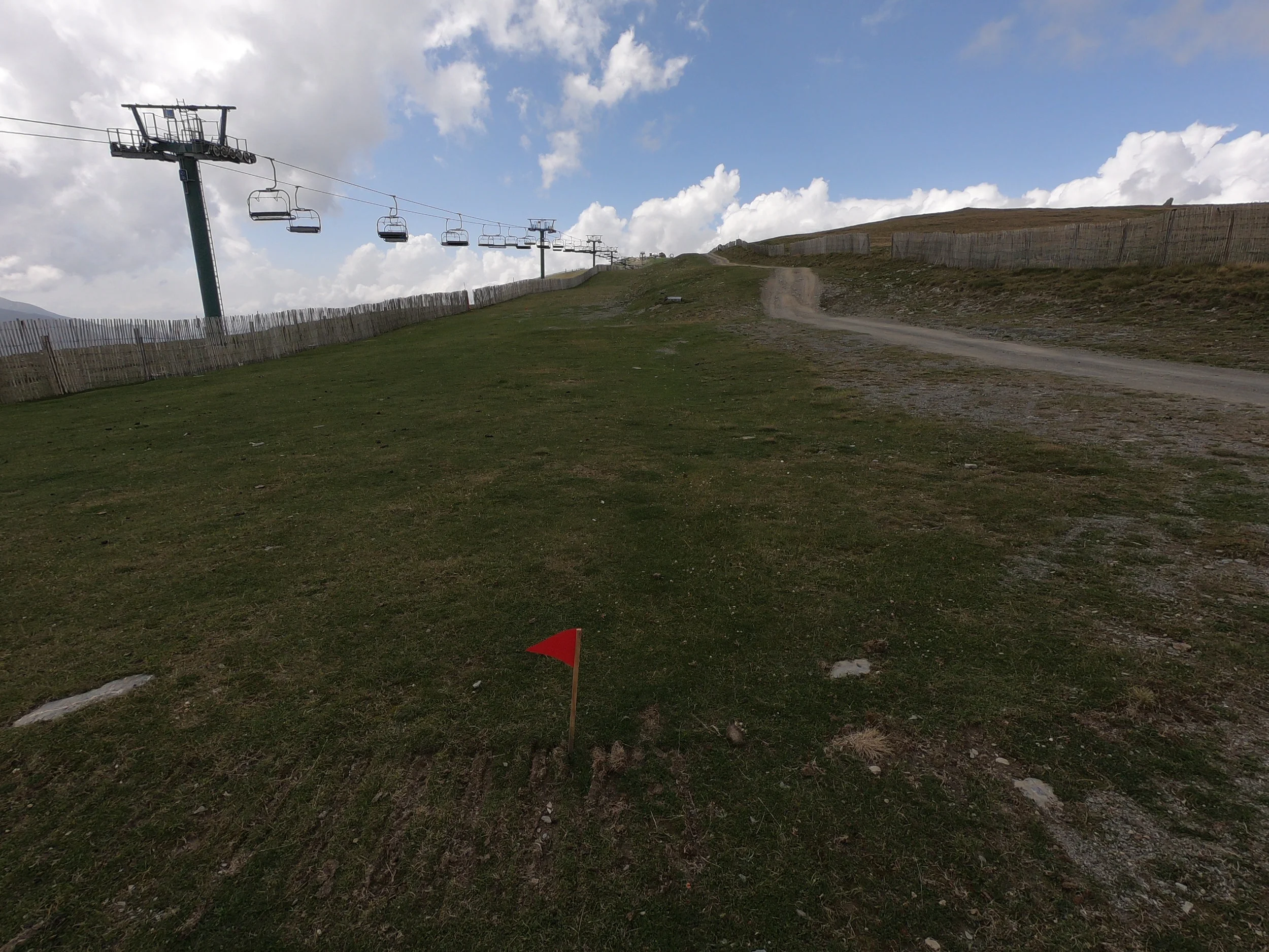The red flags show us going uphill along the fence on the left (not on the gravel road). We run nearly underneath the chairlift. This is about 11 km into the race.