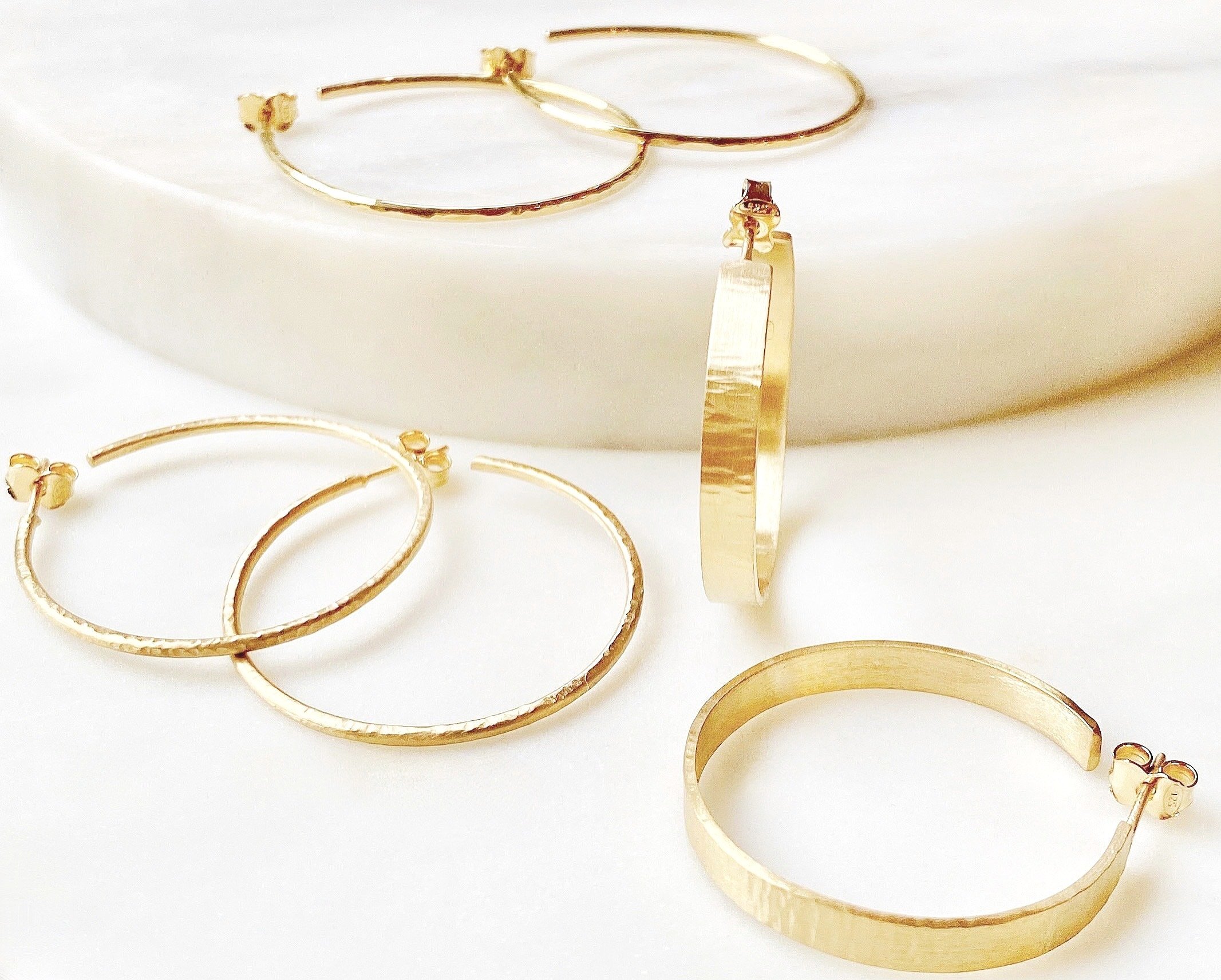 Handcrafted brushed gold large hammered hoops.