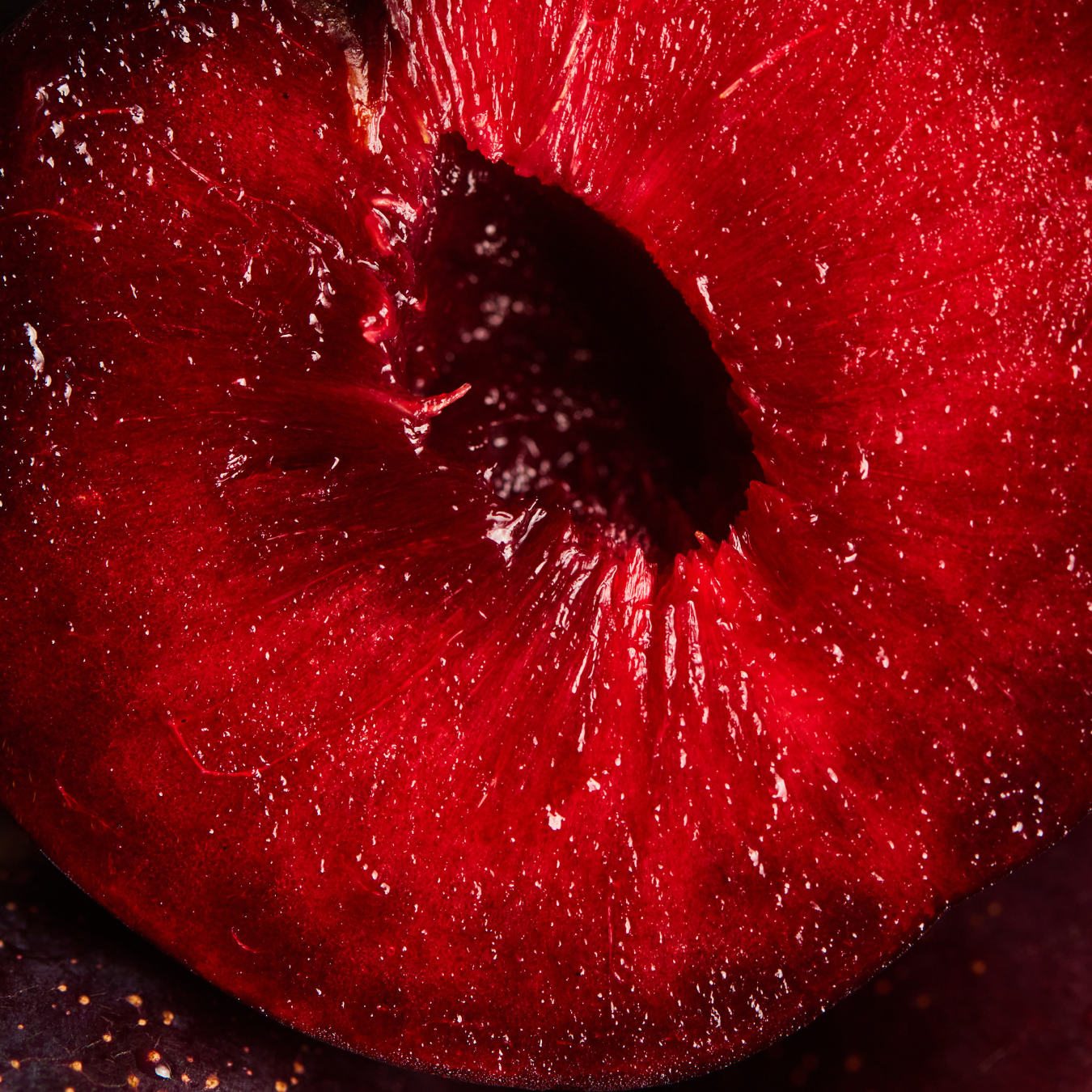Close-up of a ripe red cherry, sliced in half, showing the juicy interior.