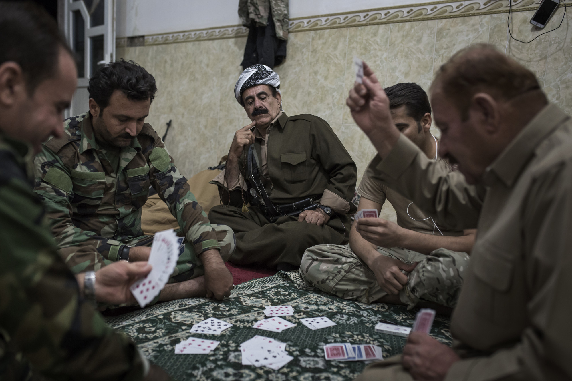  Peshmerga officers play cards the night before a Kurdish assault on an Islamic State held village. 