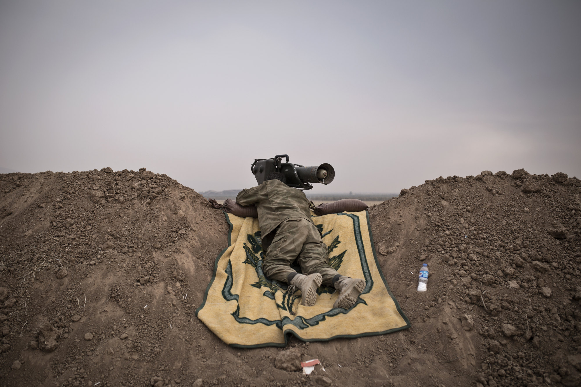  A Kurdish soldier watches an Islamic State held village through the scope of a German anti-tank weapon. 