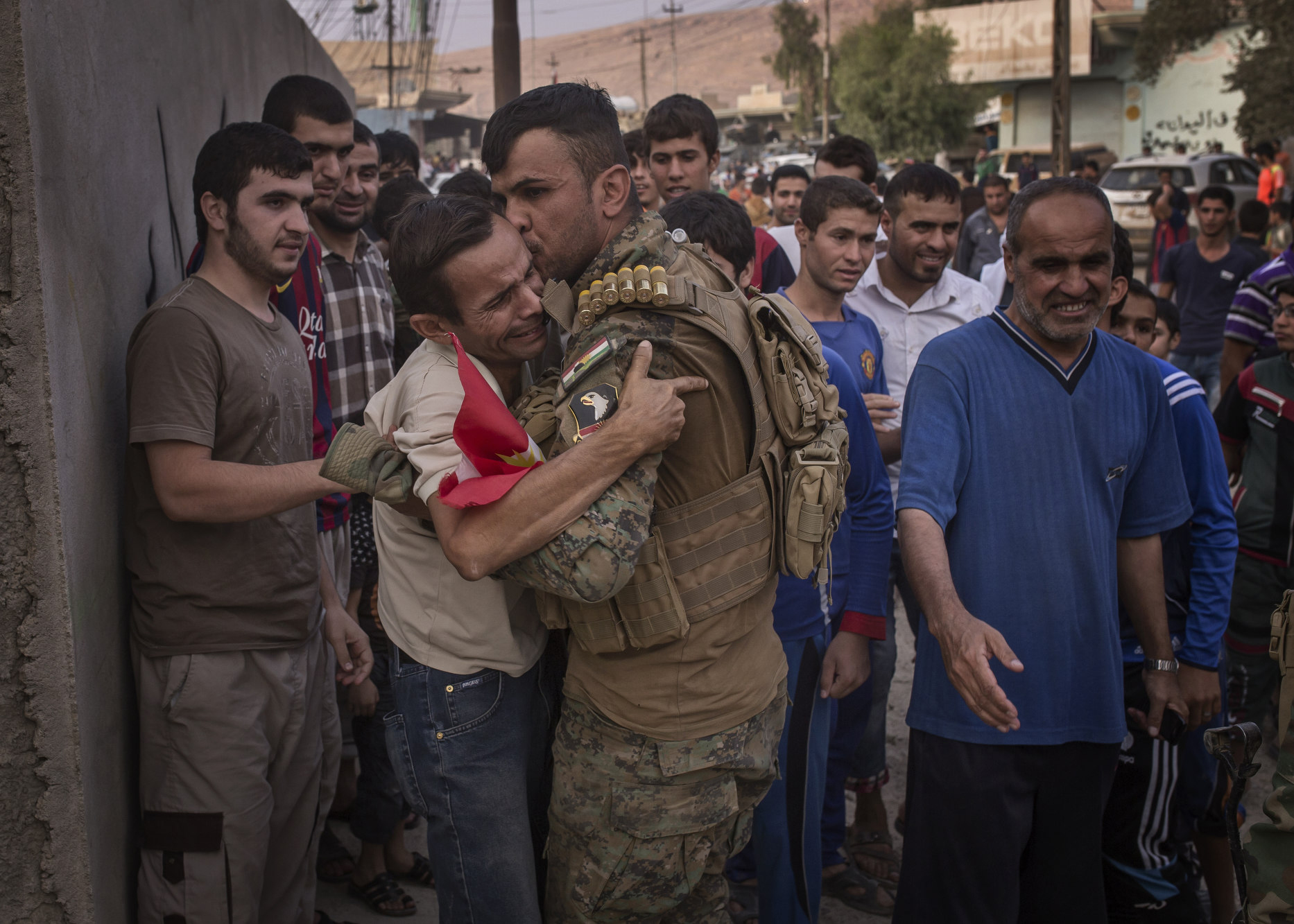  A local man collapses in the arms of a Kurdish soldier as his village is liberated from Islamic State control. 