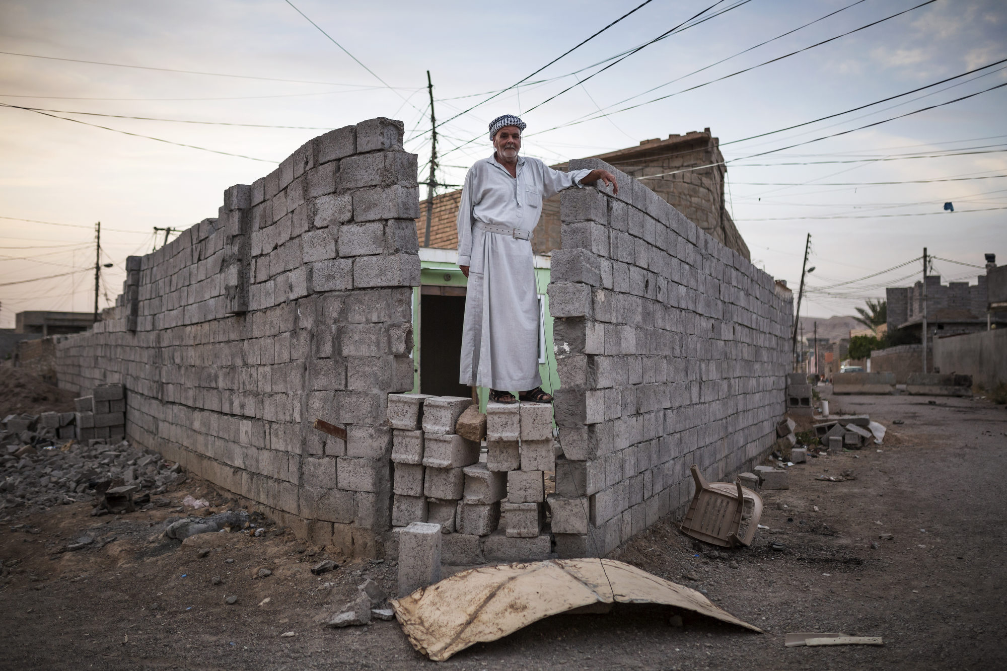  A man stands on a wall built to protect his property from clashes between Kurdish and Turkman forces. 