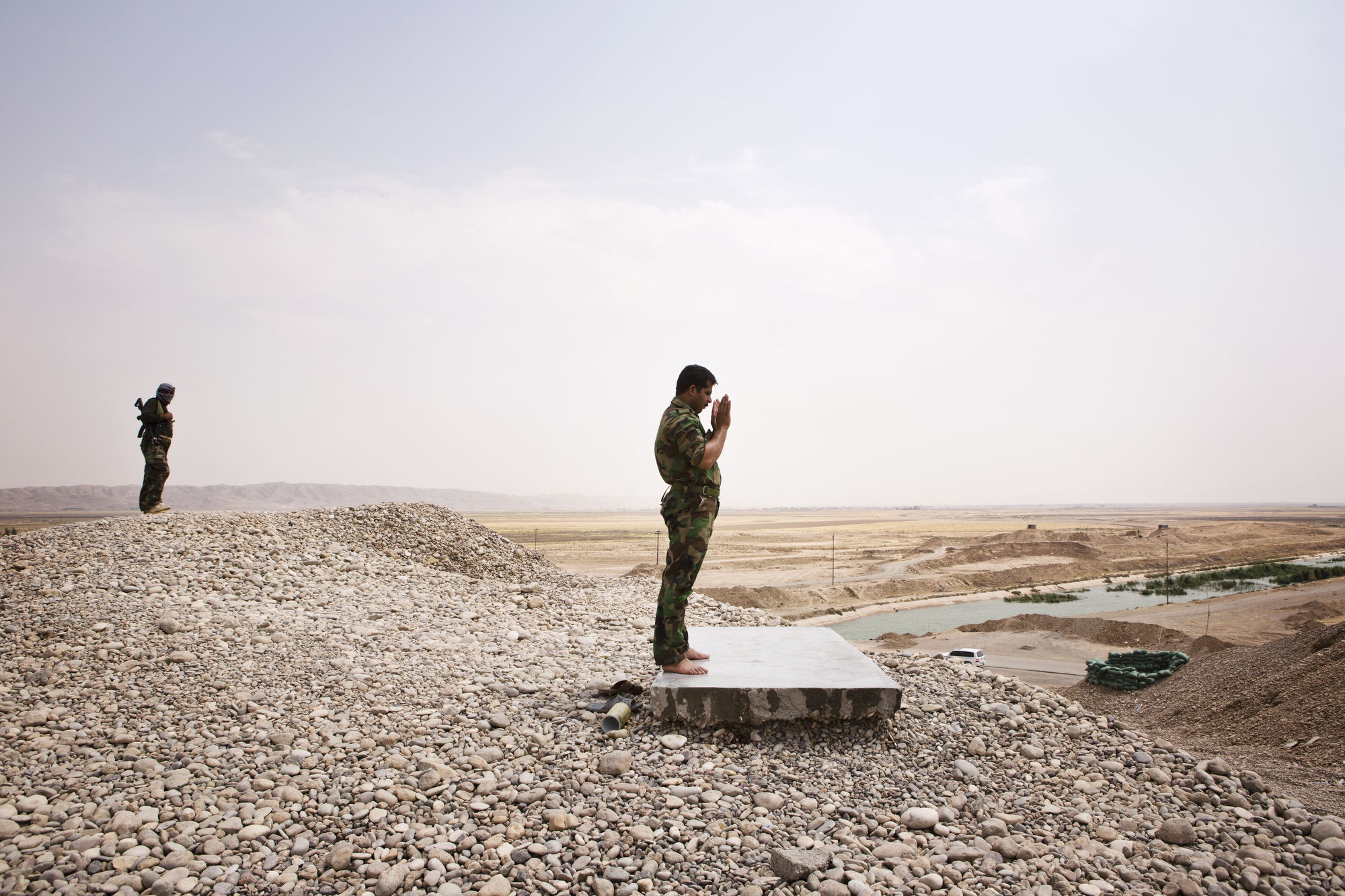  A Peshmerga prays at a front line position. 