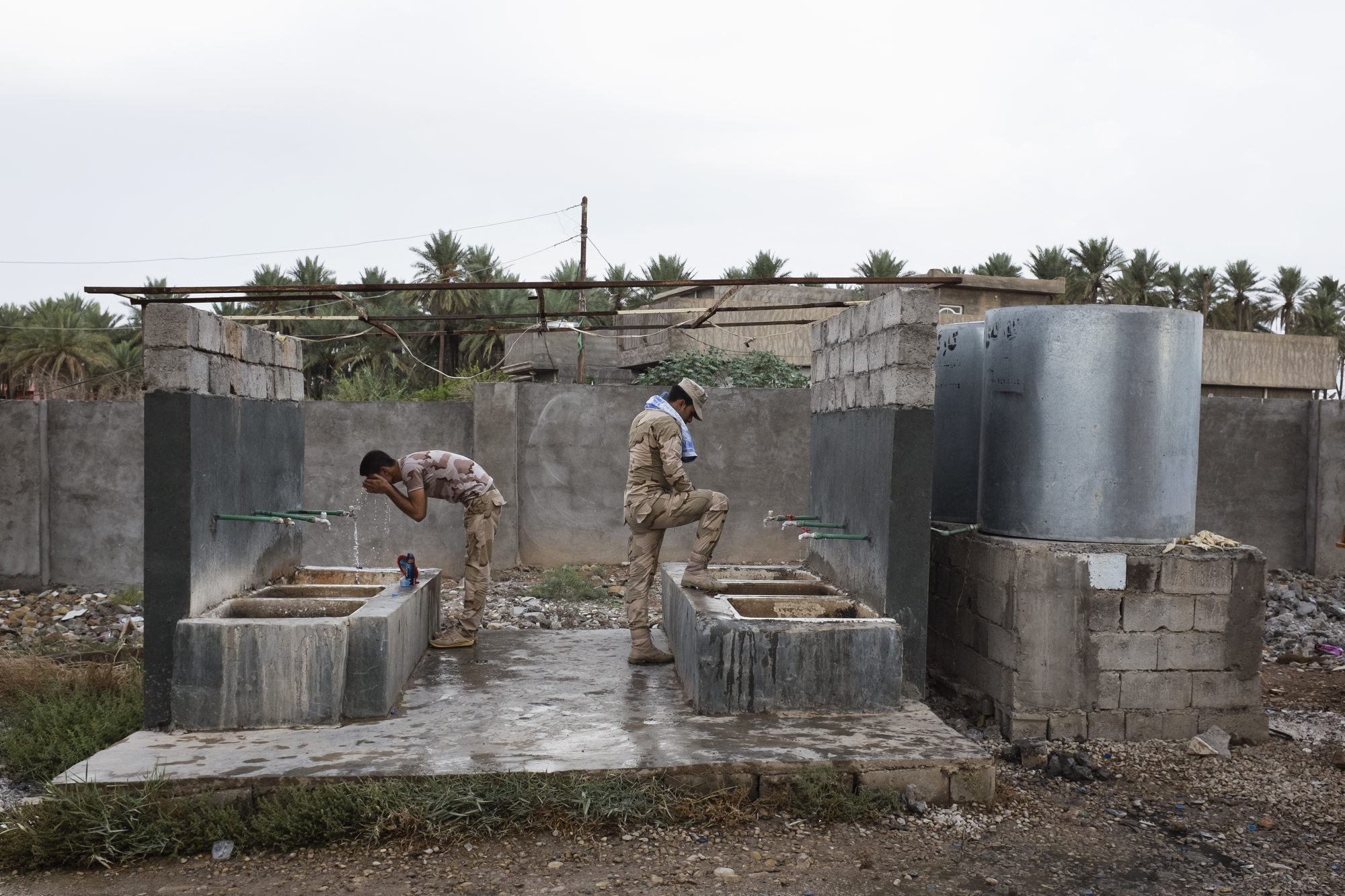  Peshmerga have a morning wash at a base. 