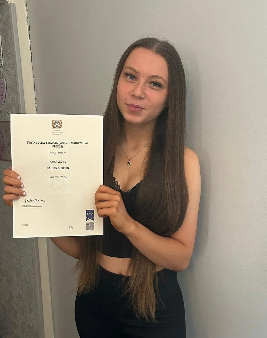 Caitlin Dickson proudly displays her certificate of achievement