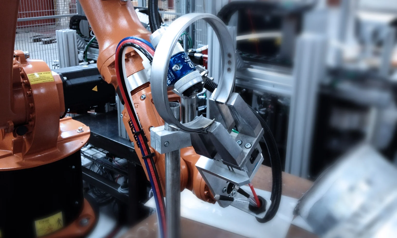 DRY LUBE APPLICATION Robot system for application of dry lube onto steel clamp rings.