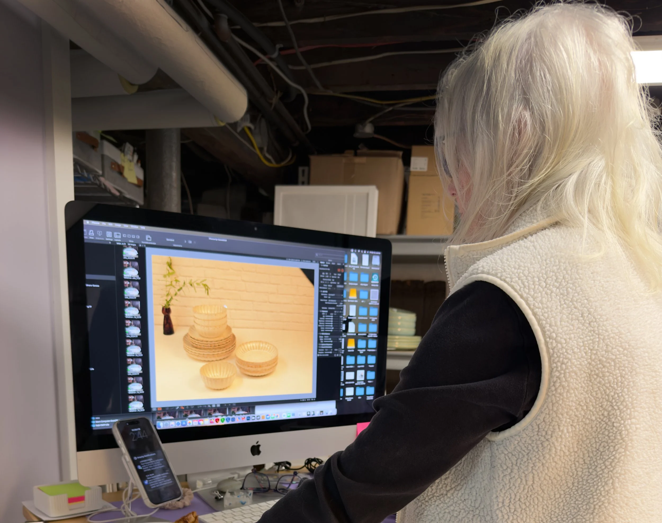 Photographer at computer assessing image.