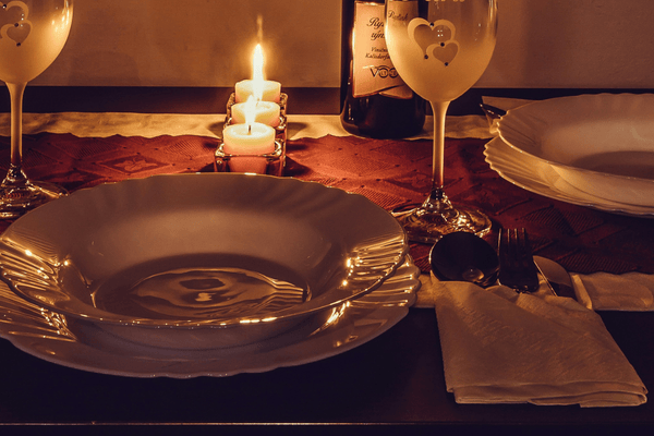 Candlelit dinner table with wine glasses set for a romantic night out