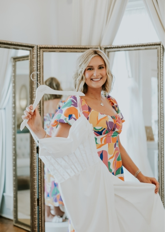 Bride holding a wedding dress on a hanger