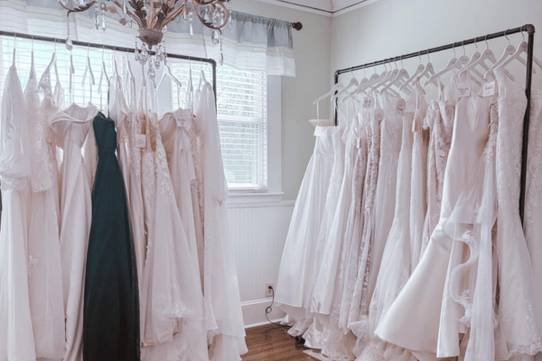 A bridal shop with two racks of white wedding dresses, one with a surprising green dress