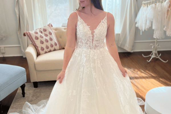 Bride wearing an A-line wedding dress with a deep V-neckline, lace bodice, and flowing tulle skirt
