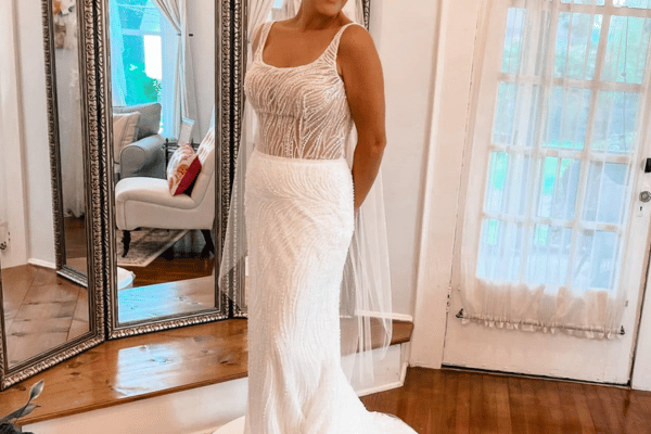 Bride wearing a beaded mermaid wedding dress with a scoop neckline and illusion bodice