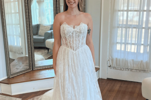 Bride wearing a strapless sweetheart wedding dress with a lace bodice, flowing A-line skirt, and floral lace detailing