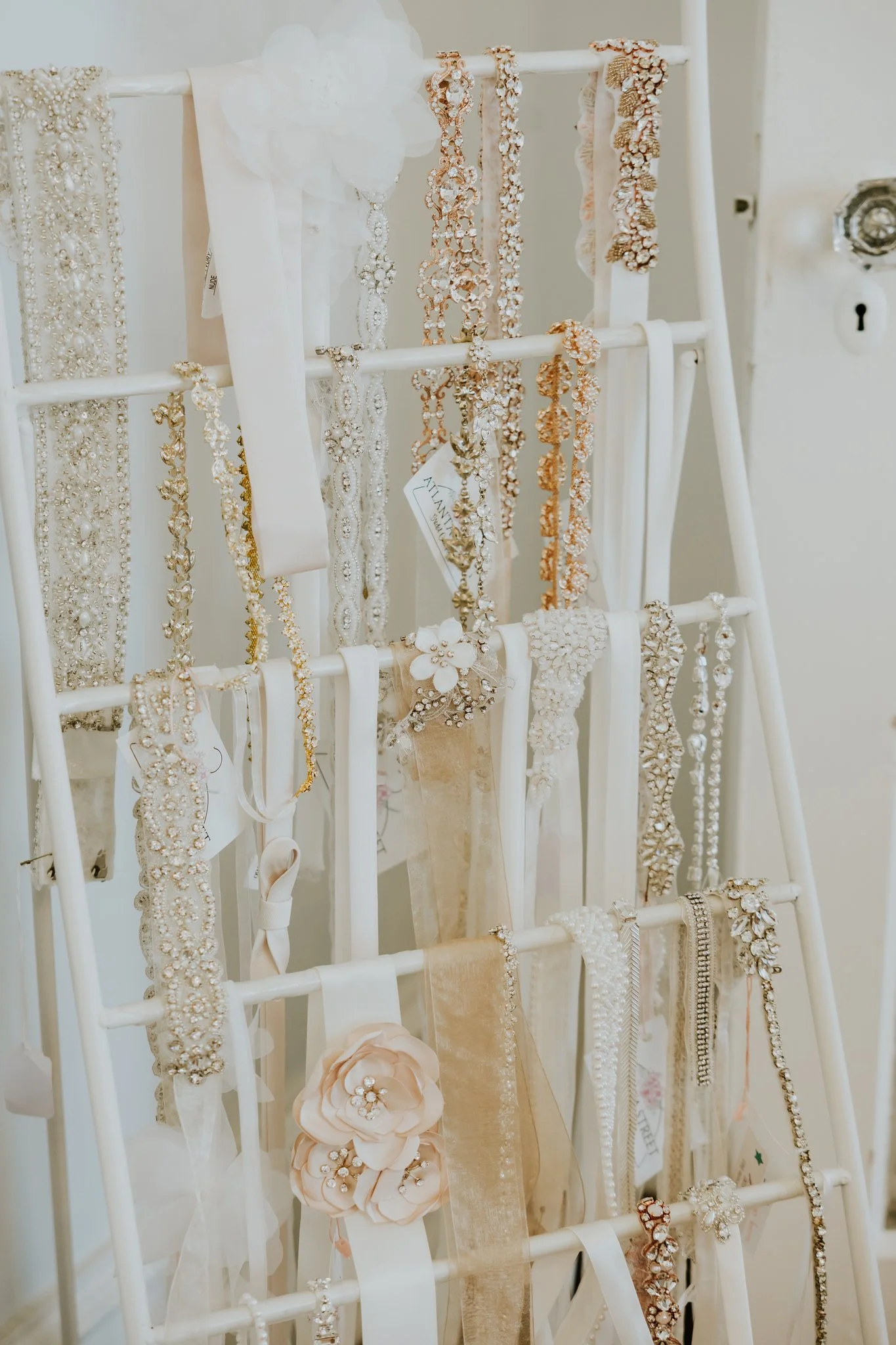 Bridal accessories display with wedding belts, sashes, and jewelry inside Atlanta Street Bridal boutique.