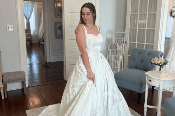 Bride wearing a satin ball gown wedding dress with a structured bodice and full skirt.