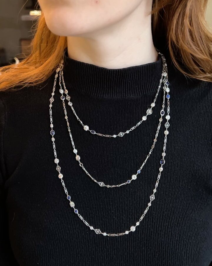 A Belle Epoque long chain necklace, c. 1910, designed as as series of spectacle set old mine and rose cut diamonds with cushion shaped sapphire detail on an open scroll link platinum chain. Available @simonteaklejewelry #belleepoquejewelry #belleepoq
