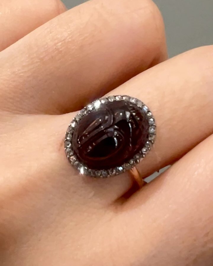 An antique garnet ring, the carved rhodolite garnet scarab with a diamond surround, c. 1890, mounted in silver and gold, with later shank addition. Available @simonteaklejewelry #antiquegarnet #antiquegarnetring #antiquescarab #antiquescarabring #sca