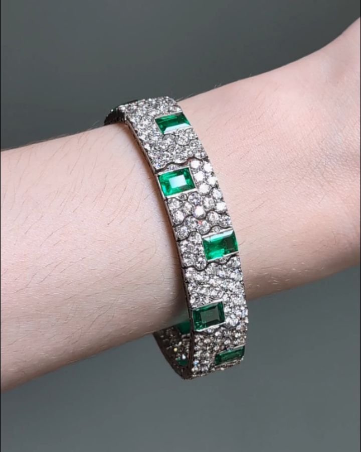 An Art Deco emerald and diamond bracelet by Charles Holl, designed as a series of twelve rectangular cut emeralds set in a zig zag pattern within an articulated band of paver set diamonds, mounted in platinum. Paris circa 1930. Available @simonteakle