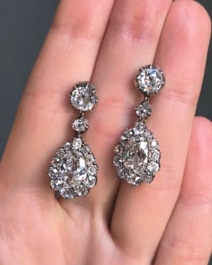 A pair of antique diamond earrings, each designed with a removable pear and old mine cut diamond cluster drop suspended from a single collet, mounted in silver and gold. Circa 1870. Available @simonteaklejewelry #antiquediamondearrings #antiquediamon