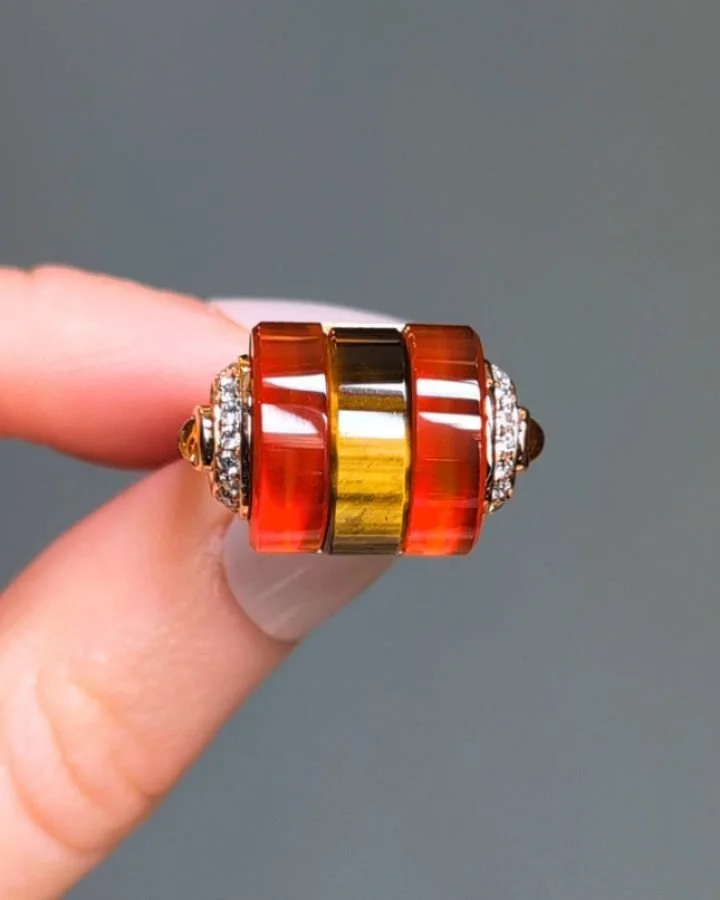 A carved carnelian and tiger's eye 'Abacus' ring by Kia Schwan, set in an 18k rose gold diamond and yellow sapphire mounting. Available @simonteaklejewelry #kiaschwan #kiaschwanjewelry #kiaschwanring #statementring #abacusthree #tigerseyering #carved