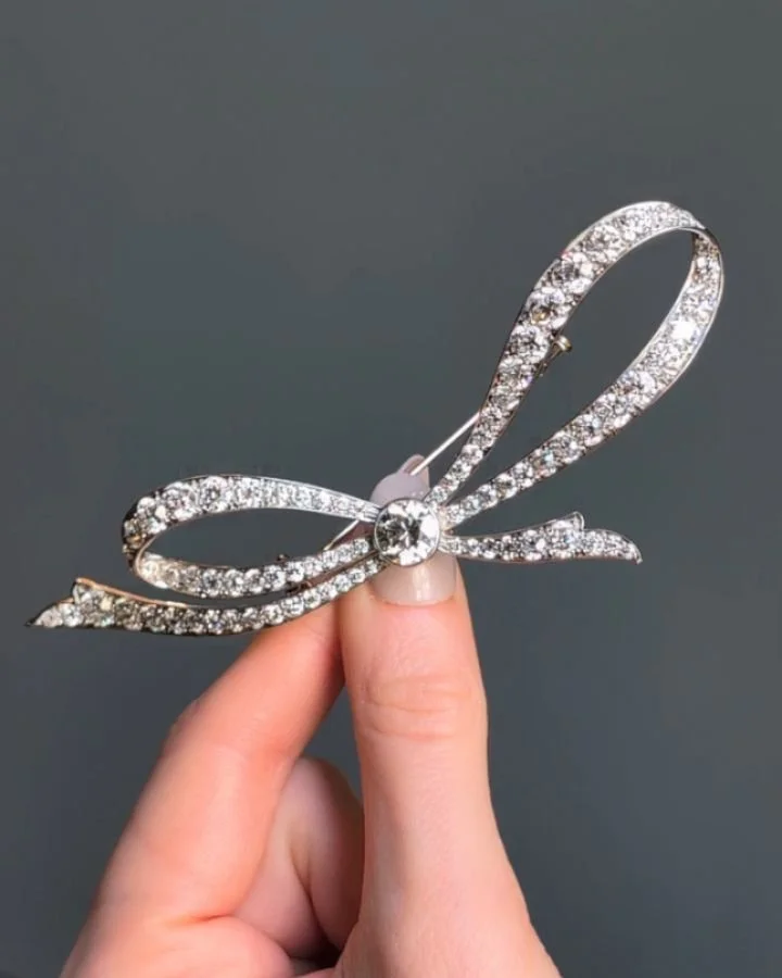 A Belle &Eacute;poque diamond bow brooch by Tiffany, the central old European cut diamond with a scrolled loop bow, mounted in platinum. New York circa 1915. Available @simonteaklejewelry #belleepoquebrooch #belleepoquebeauty #tiffanybrooch #diamondb