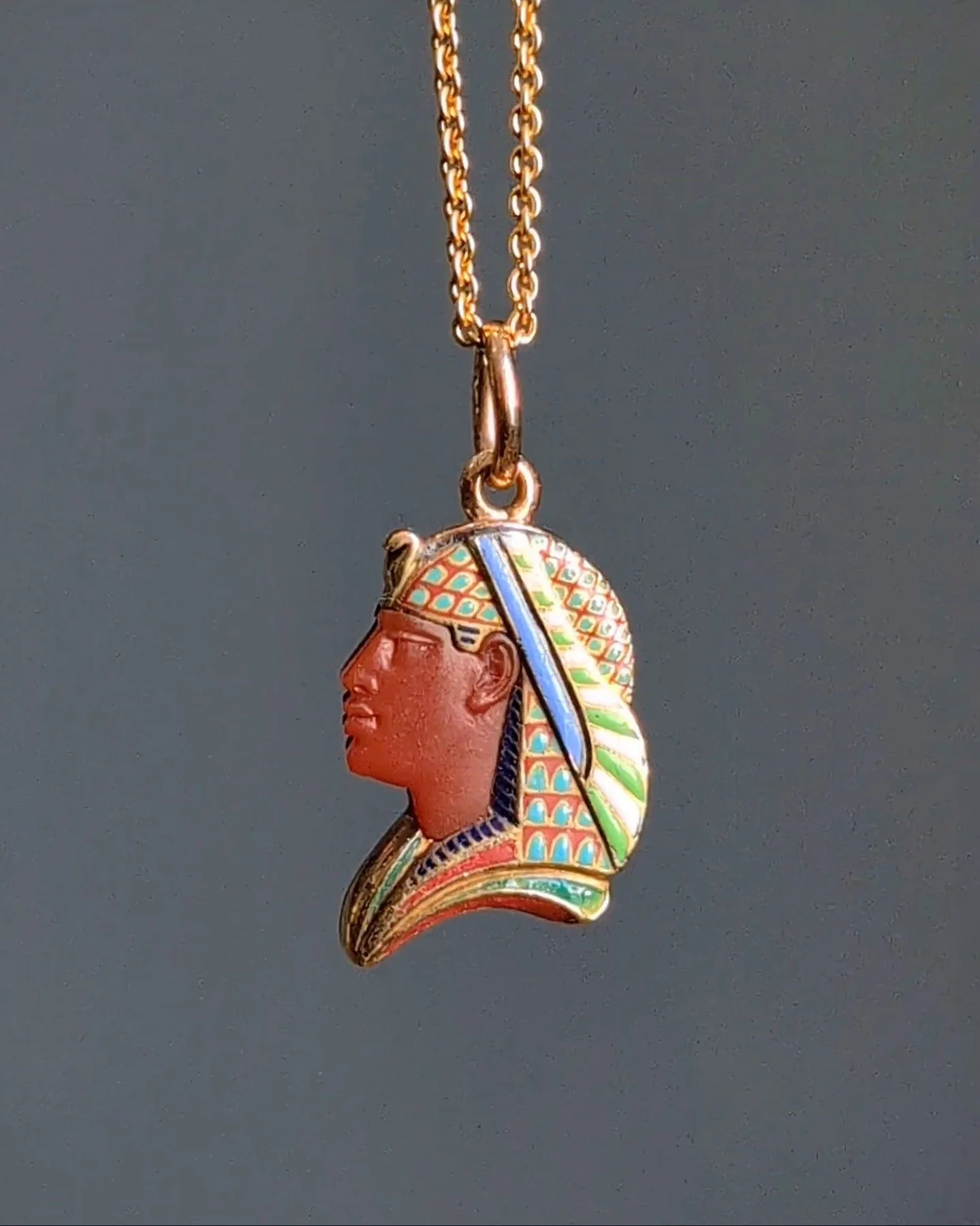 An antique Egyptian revival pendant, designed as a Pharaoh profile with a carved carnelian face with an enameled headdress mounted in gold. Circa 1880. Available $4,500 @simonteaklejewelry #egyptianrevival #egyptianrevivaljewelry #egyptianjewelryneck
