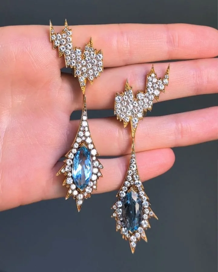 A pair of aquamarine and diamond earrings by Andrew Grima, London, each pave set diamond top of abstract form suspending a navette shaped aquamarine within a pave set diamond stylized icicle surround, mounted in 18kt gold. Circa 1970. Available @simo